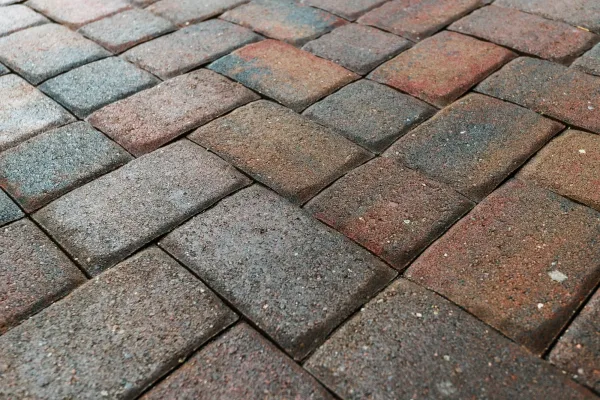 Close up showing driveway area sealant to protect the bricks paving. Sealcoating background for new